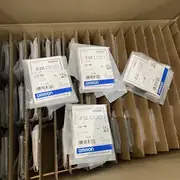 Omron E3Z-T86 emitter and receiver pair mounted on opposite sides of a conveyor - the green stability LED on the receiver confirming a clean signal across the gap