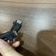Omron EE-SX672 slot sensor — hand holding two units showing the EE-1001 connector end with four solder pins visible on each unit
