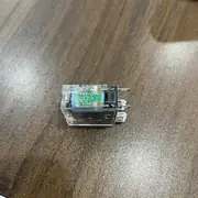 Omron G2R-2-SND DC24V DPDT 8-pin plug-in relay — front view showing the clear acrylic case with the LED indicator (lit, indicating energized coil) and the white mechanical flag indicator visible inside