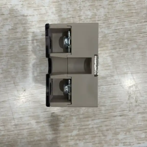 Omron G3NA-D210B-UTU DC5-24 solid state relay — top-down view showing the hockey-puck style gray plastic housing with two screw-mounting holes at the top and bottom and a transparent centre cover over the output terminals