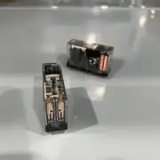 Omron G7SA-2A2B DC24 safety relay — close-up of one G7SA relay showing the through-hole PCB pins on the bottom, the spring-loaded contact mechanism visible through the clear housing, and the Omron G7SA-2A2B 24VDC label