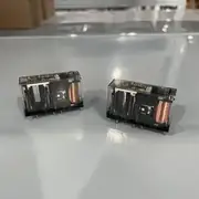 Omron G7SA-2A2B DC24 safety relay — two transparent G7SA relays side by side on a reflective surface showing the copper coils, the black plastic contact mechanism, and the Omron G7SA-2A2B 24VDC MADE IN JAPAN labels