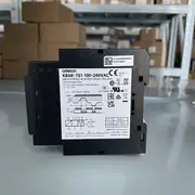 K8AK-TS1 relay removed from the box showing the 22.5 mm DIN-rail body, PTC input terminals T1 / T2, and the TEST/RESET button