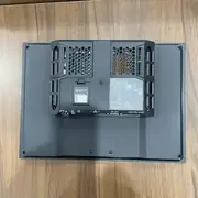 Omron NA5-12W101B-V1 HMI — full rear view of the unit on a wooden surface showing the cooling vents, mounting clips, SD card slot, RS-232C port label, 24 VDC power terminal, dual Ethernet ports labelled 1 and 2, and Host/Slave USB ports