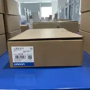 Omron NB7W-TW11B — single brown cardboard box on a blue plastic surface showing TYPE NB7W-TW11B / 可编程控制终端 / VER. 1.1 / KCC-REM-OMR-NB-00002 KC mark / lot 02320M / barcode / OMRON Corporation / MADE IN CHINA / blue OMRON band