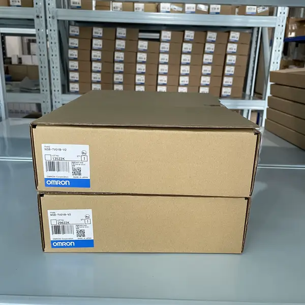 Omron NS8-TV01-V2 NS-series HMI — two stacked retail boxes on warehouse shelving showing Omron type labels TYPE NS8-TV01B-V2 (bezel variant sibling), LOT 13522K / 29622K, OMRON Corporation, Made in Japan, QTY 1