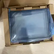Omron NS8-TV01-V2 NS-series HMI — top-down view of the unit inside anti-static bag with Omron logo, RUN LED visible at top right, 8.4-inch touch panel display