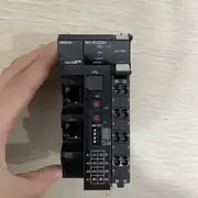 Omron NX-ECC201 EtherCAT coupler — front view held in hand showing OMRON label, EtherCAT conformance marking, RUN / TS / ERR / UNIT PWR / L/A IN / L/A OUT LEDs, IN and OUT EtherCAT RJ45 ports, ID selector switches, ON switch, and 16-position screwless push-in terminal block with A1/B1 through A7/B7 power markings