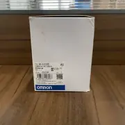 Omron NX-ECC202 EtherCAT coupler — retail box at different angle on table showing the same NX-ECC202 type label and Omron blue band