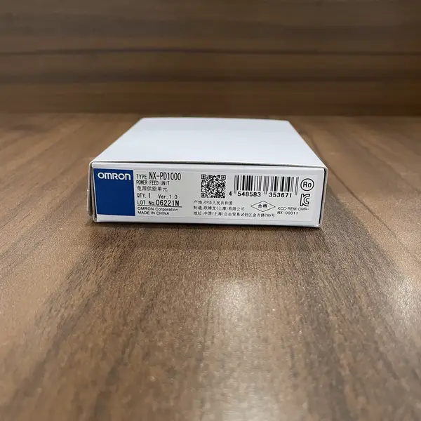 Omron NX-PD1000 NX unit power supply — 12 mm wide NX-series module with the orange locking slider visible on the right side, screwless push-in terminal block on top with 8 terminals (IOV/V+, IOG/V−, FG pairs)