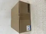 Omron R88D-1SN08H-ECT — upright brown Omron cardboard shipping carton on a tiled surface showing the side-panel label with TYPE R88D-1SN08H-ECT / AC SERVO DRIVE / MASS 2.0 kg / LOT / QTY 1 / KCC-REM-OMR-R88D-00073 / RCM / KC / EAC marks / Chinese safety labels / barcode / OMRON Corporation / MADE IN CHINA / blue OMRON band / package handling icons (keep dry, fragile, this side up)