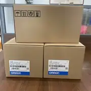 Omron R88M-1M75030H-S2 servo motor — three stacked brown shipping boxes showing packaging labels with TYPE R88M-1M75030H-S2, AC SERVO MOTOR, QTY 1, OMRON Corporation, MADE IN THE PHILIPPINES, with handling icons (keep dry, this way up, fragile)