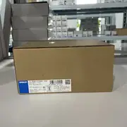 Omron S8VK-C12024 mounted on a DIN rail in a mid-size control panel - powering a CJ2M-CPU33 PLC and several CJ1W I/O units with the green DC ON LED lit.