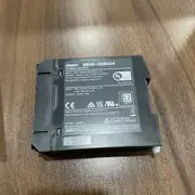 Omron S8VK-G06024 mounted on a DIN rail in a small PLC control panel - powering a CP1L-EM40DT1-D PLC and 4 expansion I/O modules with 88% efficiency, the green DC ON LED showing healthy operation