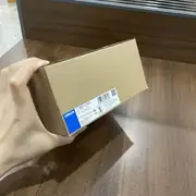 Omron S8VK-G12024 120 W DIN-rail power supply — front view showing the 40 × 124 × 125 mm covered-type housing with spring-clamp input and output terminal covers, the green DC OK indicator LED lit, and the blue output voltage adjustment trimmer visible behind the cover