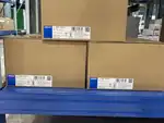 Omron S8VK-G24024 240 W DIN-rail power supply — side view showing the 35 mm DIN-rail mounting clip on the rear and the 24-27.5 VDC output voltage adjustment trimmer on the front face (blue)