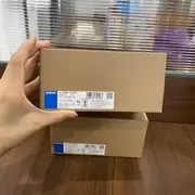 Omron S8VK-T12024 — carton held above a second box with both model labels visible