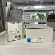 Omron S8VS-12024 switching power supply — DIN-rail-mounted 120 W unit with the green DC OK LED lit, showing the covered (finger-safe) housing and screw-terminal output block on the front
