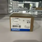 Omron TL-N10ME1 30 mm rectangular inductive sensor — installed flush against a vibrating-feeder bowl frame detecting 5 mm steel fasteners as they exit the bowl into the supply chute; IP67 housing handles the residual oil in the assembly environment