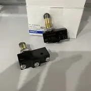 Omron Z-15GQ22-B basic switch — side view showing the lever's roller-bearing construction with the stainless-steel roller rotating freely on the plunger; suitable for high-cycle cam operation