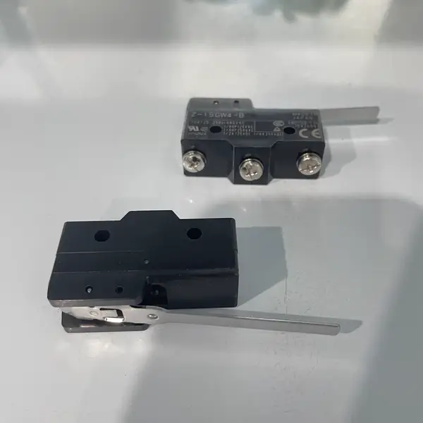 Omron Z-15GW4-B — front view of the black thermoset resin body showing the four M3.5 screw terminals on the rear, the hinge lever actuator on the front, and the Z marking on the body